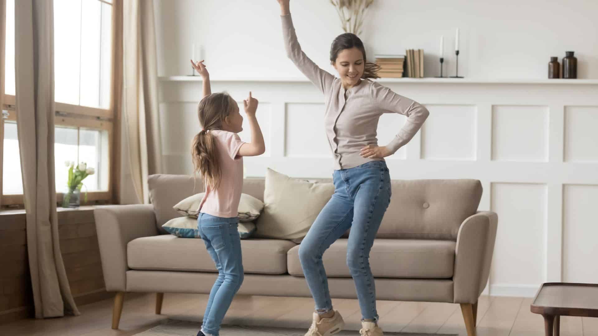 Young women dancing with child in living room