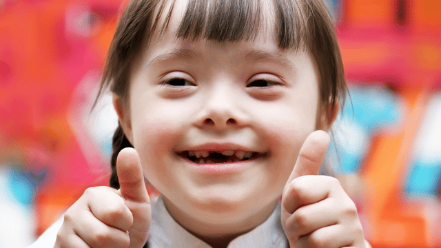 Special needs child both thumbs up