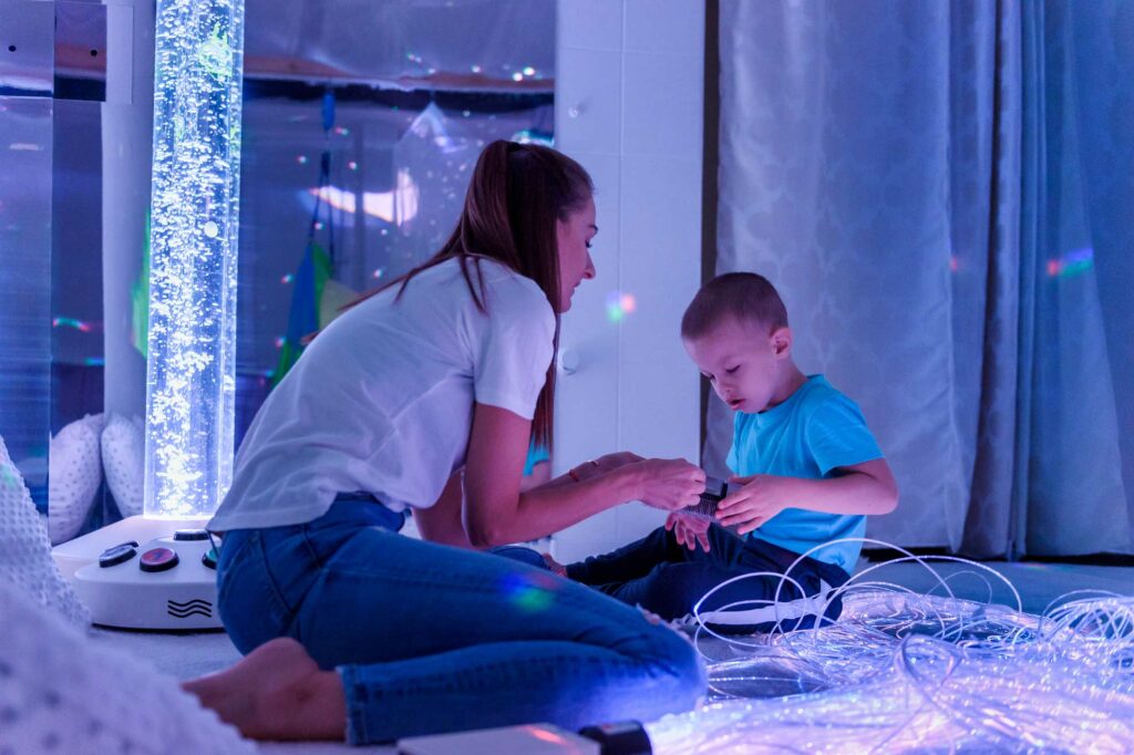 Live-In Care Professional and a child with special needs playing in a sensory room