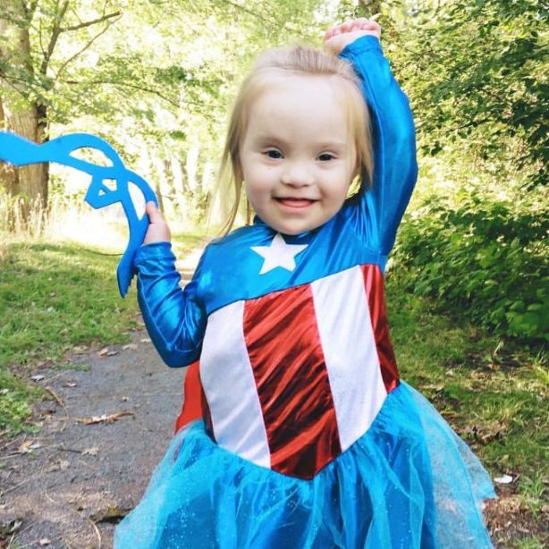 A girl with Down syndrome wearing a Captain America costume